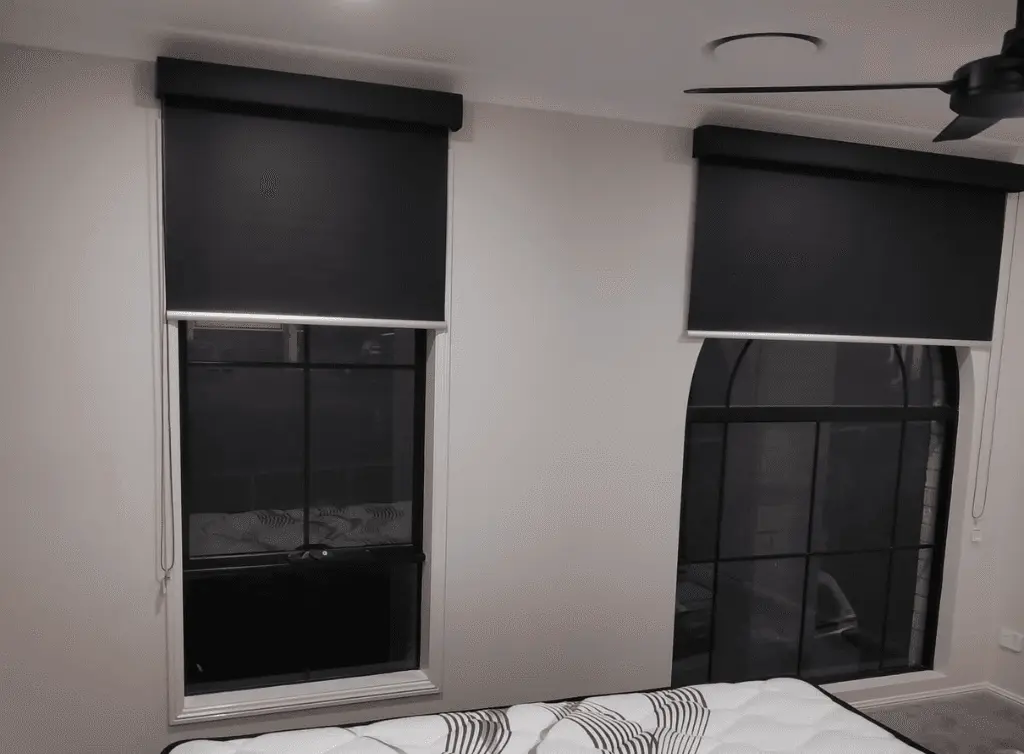 Black roller blinds in a bedroom