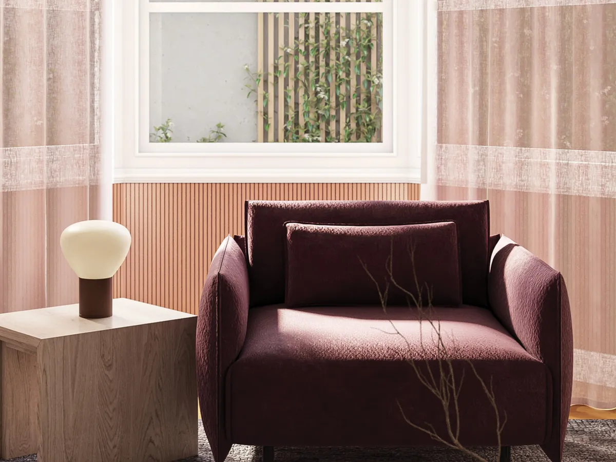 Maurice Kain Linesse blush sheer curtains beside a velvet armchair